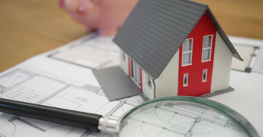 Inheritance Tax in 2026 - Part 1: Lifetime Gifts and the New Business Property Relief Rules | Hamilton Financial Model house on architectural plans with a magnifying glass, representing inheritance tax and estate planning